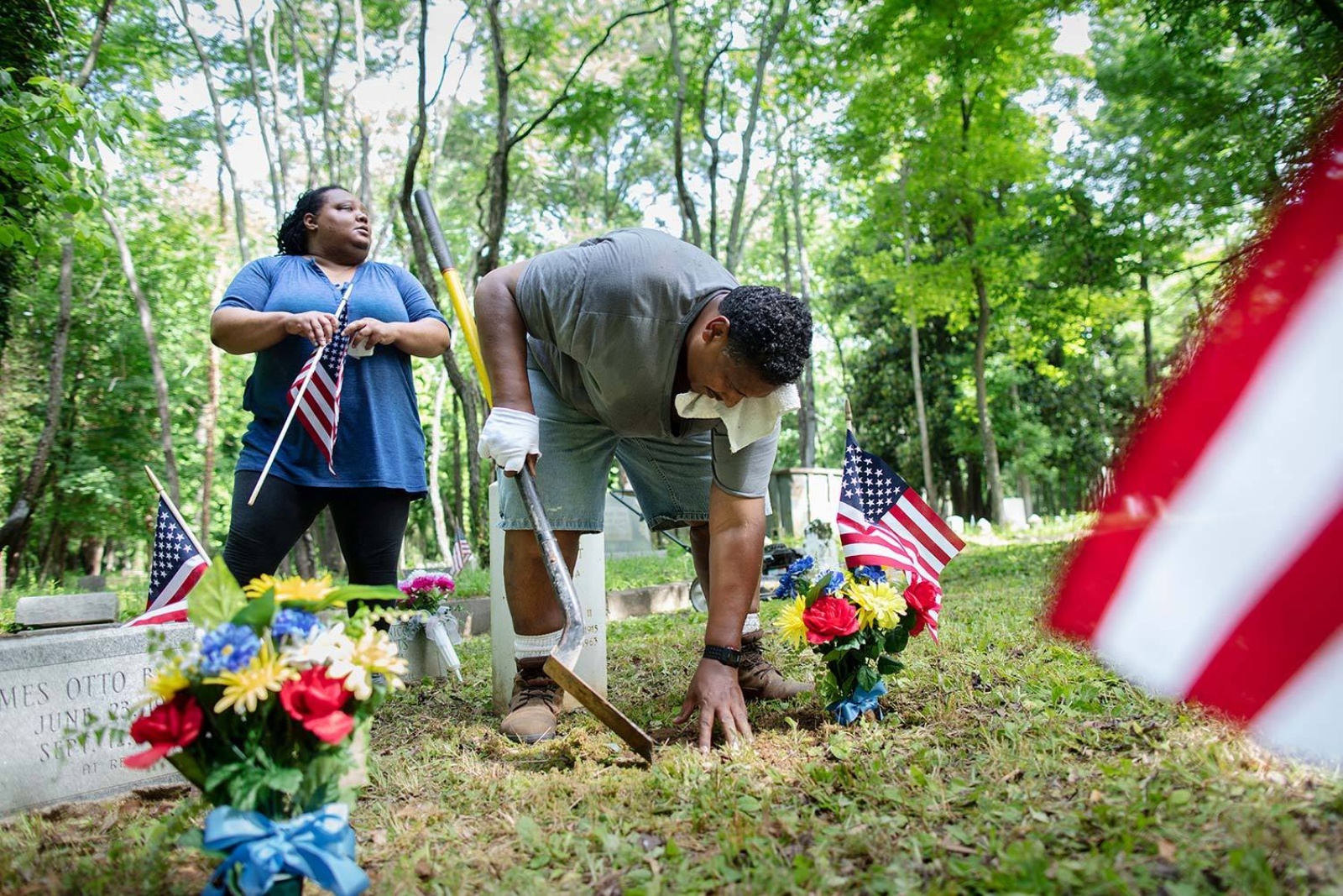 Brian Palmer photograph of two volunteers clearing grave sites for the East End Cemetery project