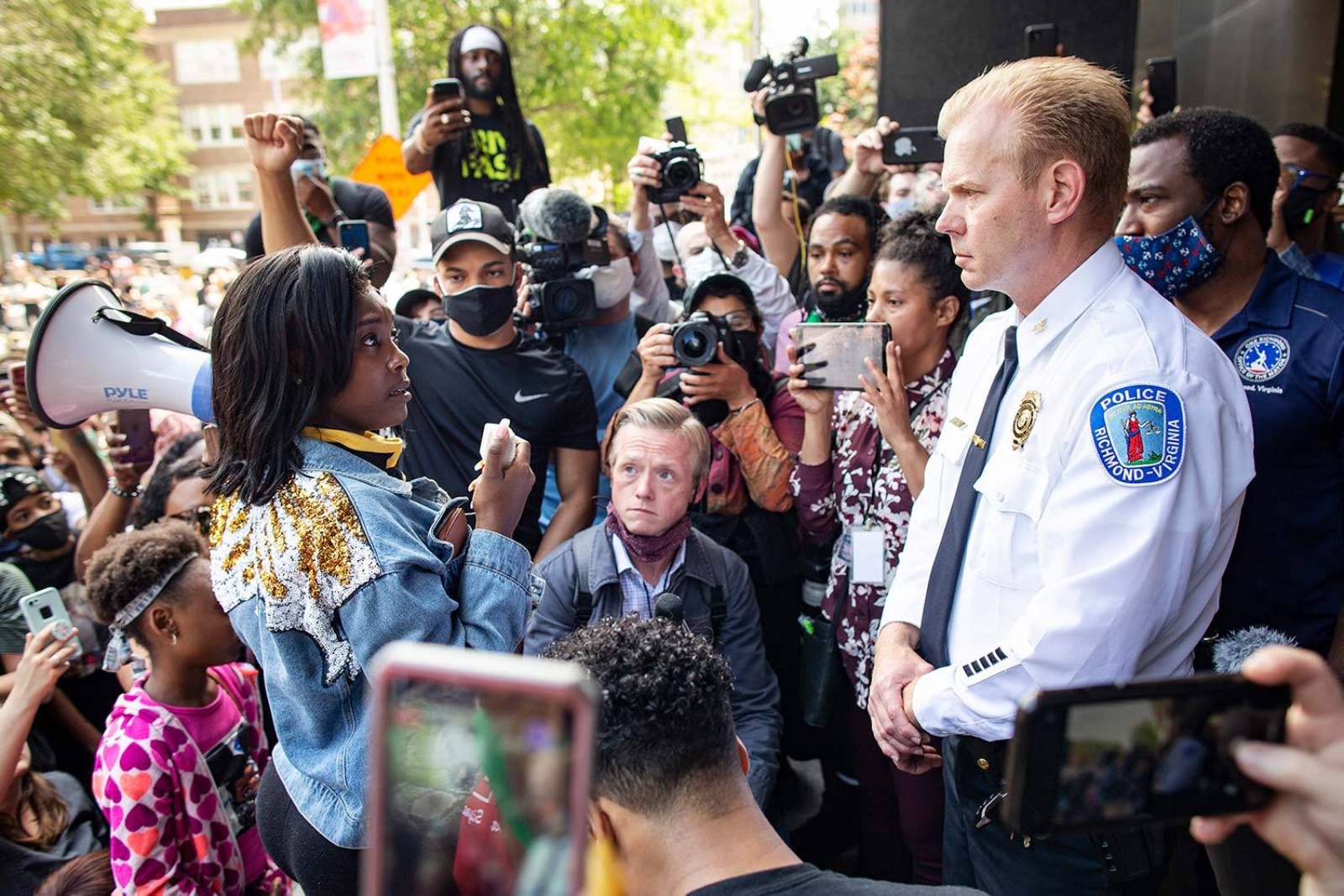 Brian Palmer photograph of female protestor looking at police chief in crowd of protestors